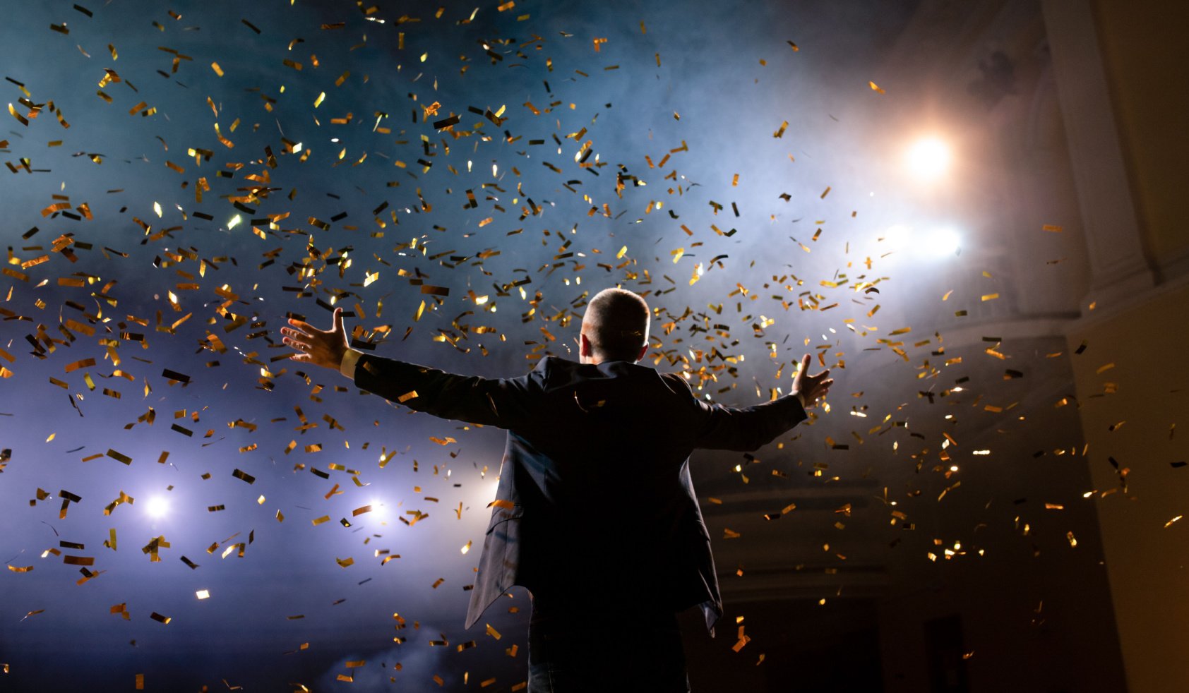 Successful businessman with arms up celebrating his victory. Celebrating success.