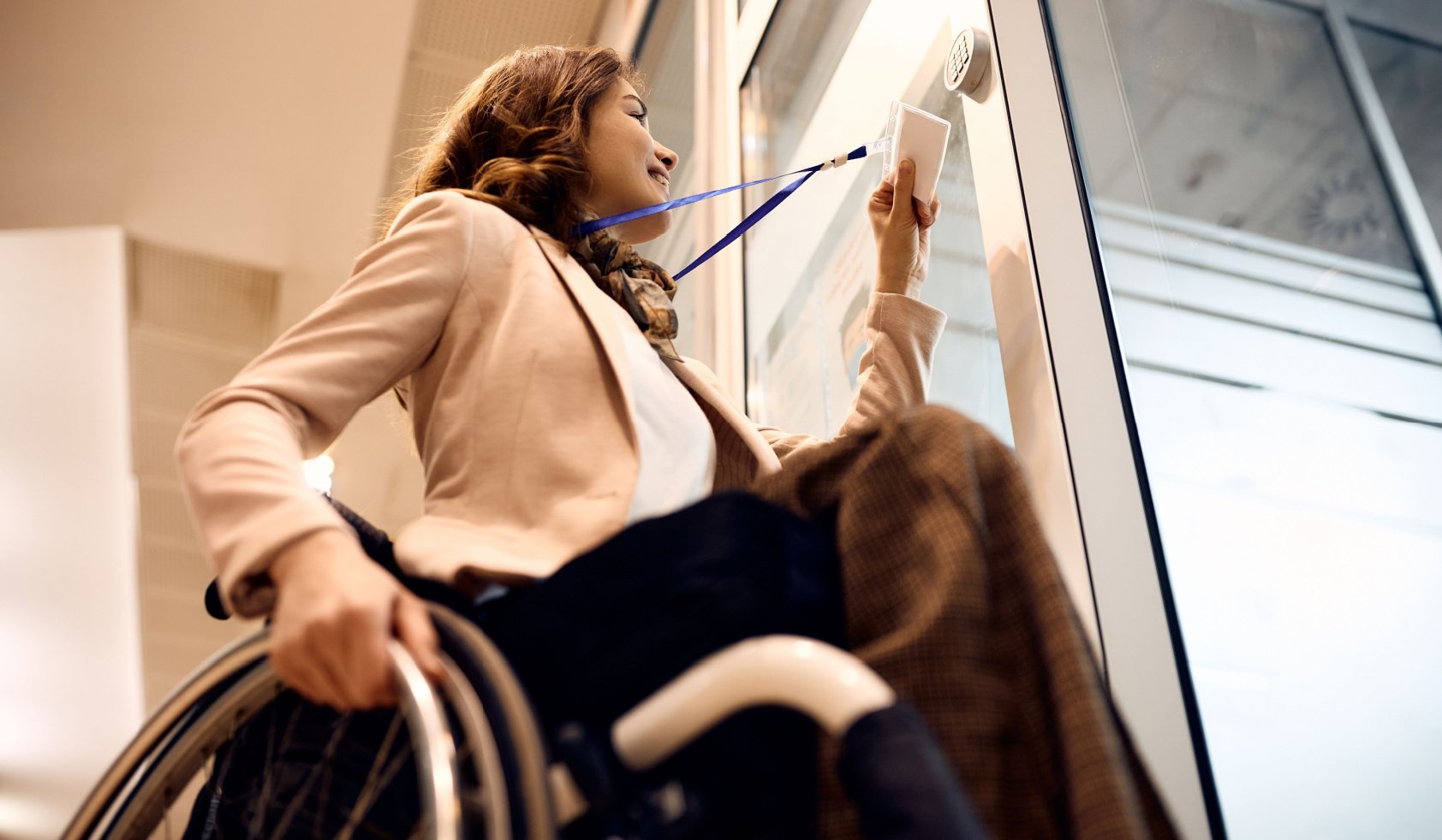 Low angle view of happy businesswoman with disability using card key to unlock office door.