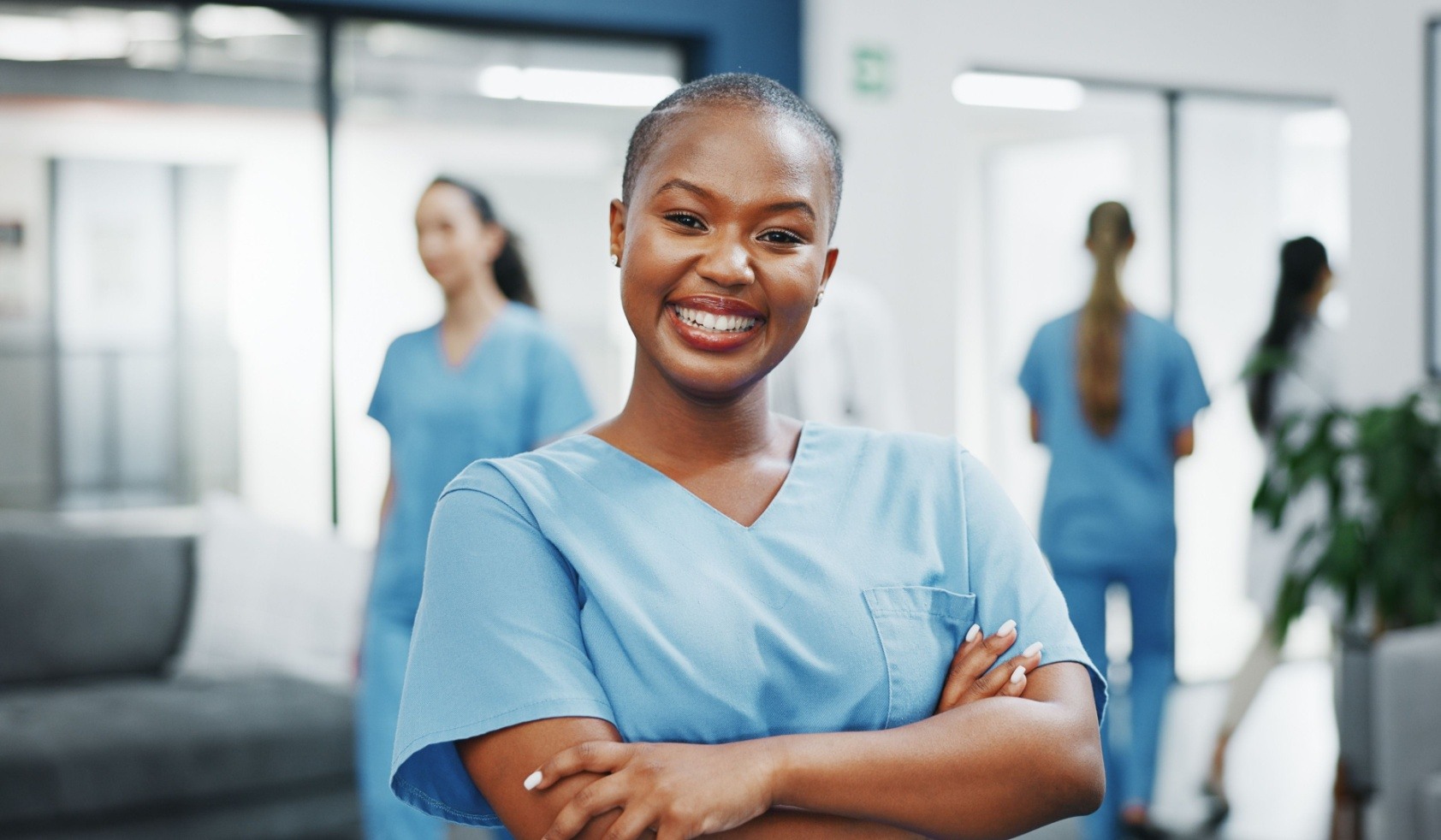 Nurse, face or arms crossed in busy hospital for about us, medical life insurance or wellness support. Smile, happy or healthcare black woman in portrait, confidence trust or help medicine internship