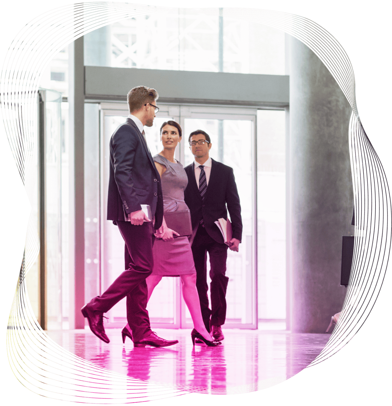 Smartly dressed woman and two suited male colleagues walking and talking in an office foyer